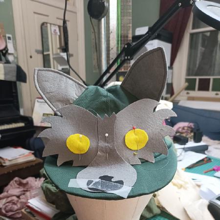 Green hat with ears and most of wolf face.